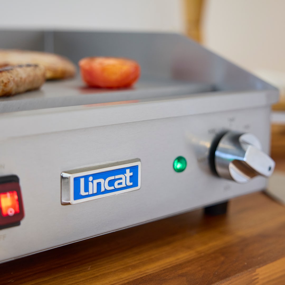 Compact electric griddle with side splash guards and removable drip tray